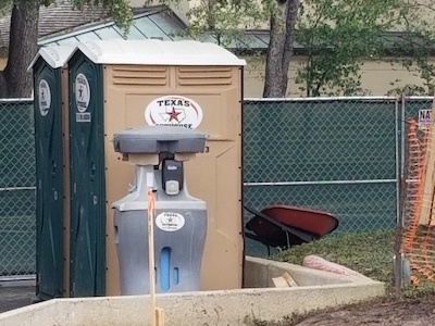 Portable toilet from Texas Outhouse helping contractor meet requirement for how many toilets per person on a construction site