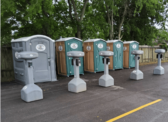 Rented outhouses at an outdoor event.