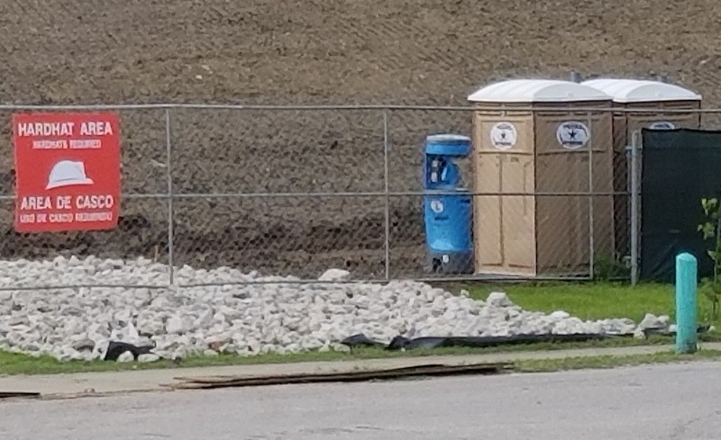 Rented portable toilets and a portable handwashing station at a construction site.
