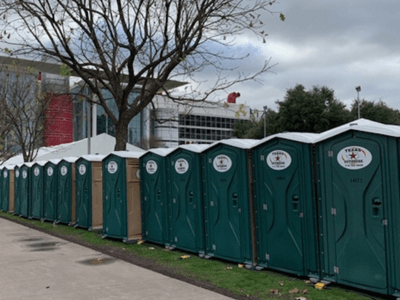 Portable restrooms from Texas Outhouse lined up outside an event venue