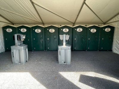 Texas Outhouse portable toilets and handwash stations placed underneath an event tent
