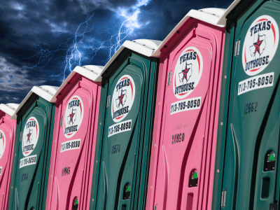Texas Outhouse portable toilet positioned outside during a storm