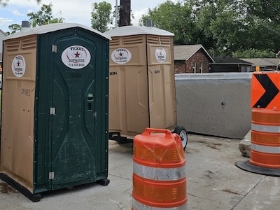 Texas Outhouse portable toilets positioned outside a construction project in Houston, TX