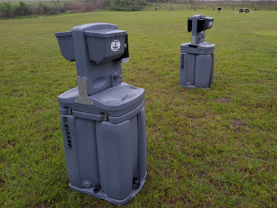 Handwashing station from Texas Outhouse positioned in a field