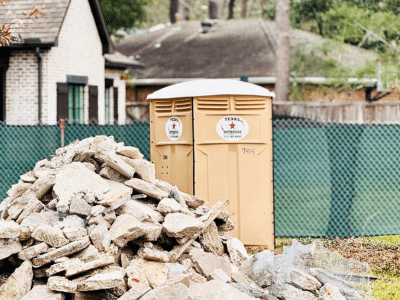 Texas Outhouse portable toilet positioned outside of a residential construction site in Houston, Texas